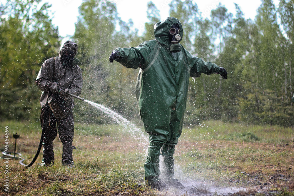 military chemists perform the process of purification from pesticides with the help of special solutions on the nature near the radioactive object