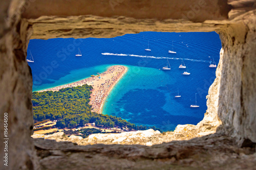 Zlatni rat beach aerial view through stone window photo