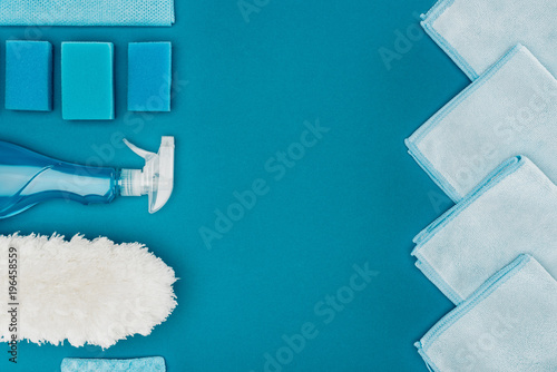 top view of row of blue rags and cleaning supplies isolated on blue photo