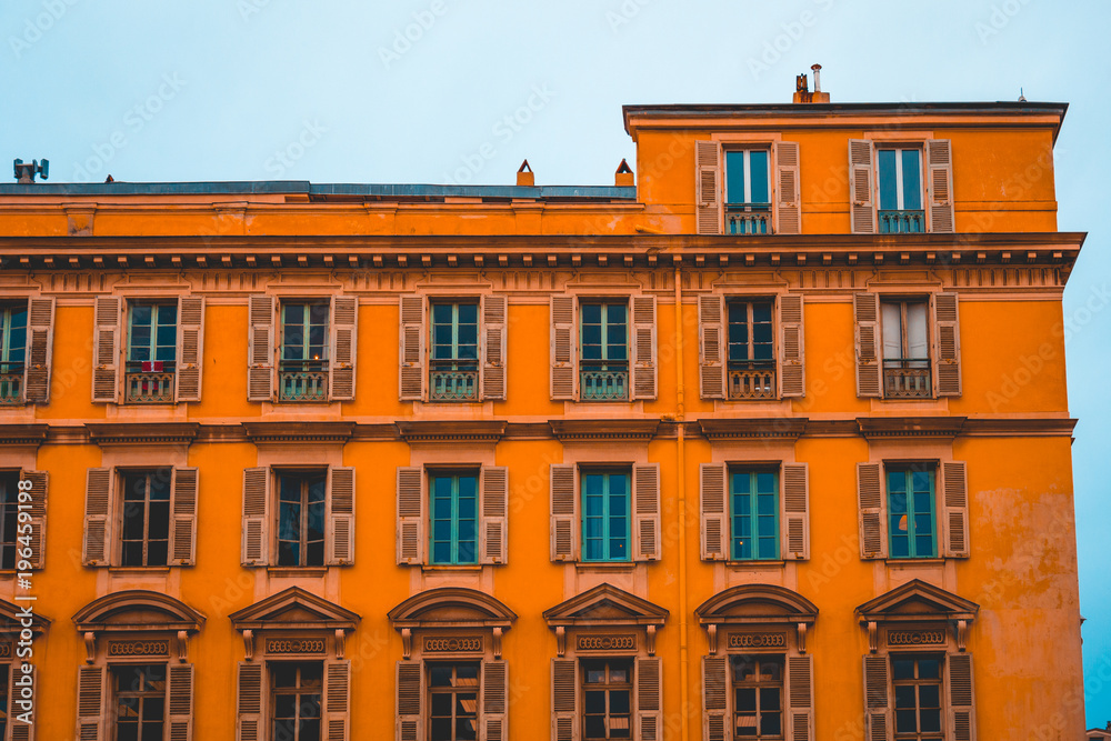 big residential building with orange facade in darken tones big residential building with orange facade in darken tones