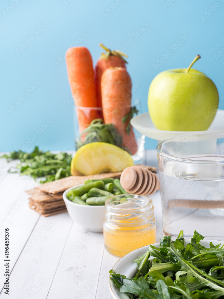 Healthy diet food on the table Arugula Green Beans Apple Water Honey Cracker Carrot Copy space Healthy diet food on the table Arugula Green Beans Apple Water Honey Cracker Carrot Copy space