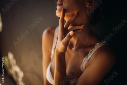 Woman in white lingerie touches her neck tender photo