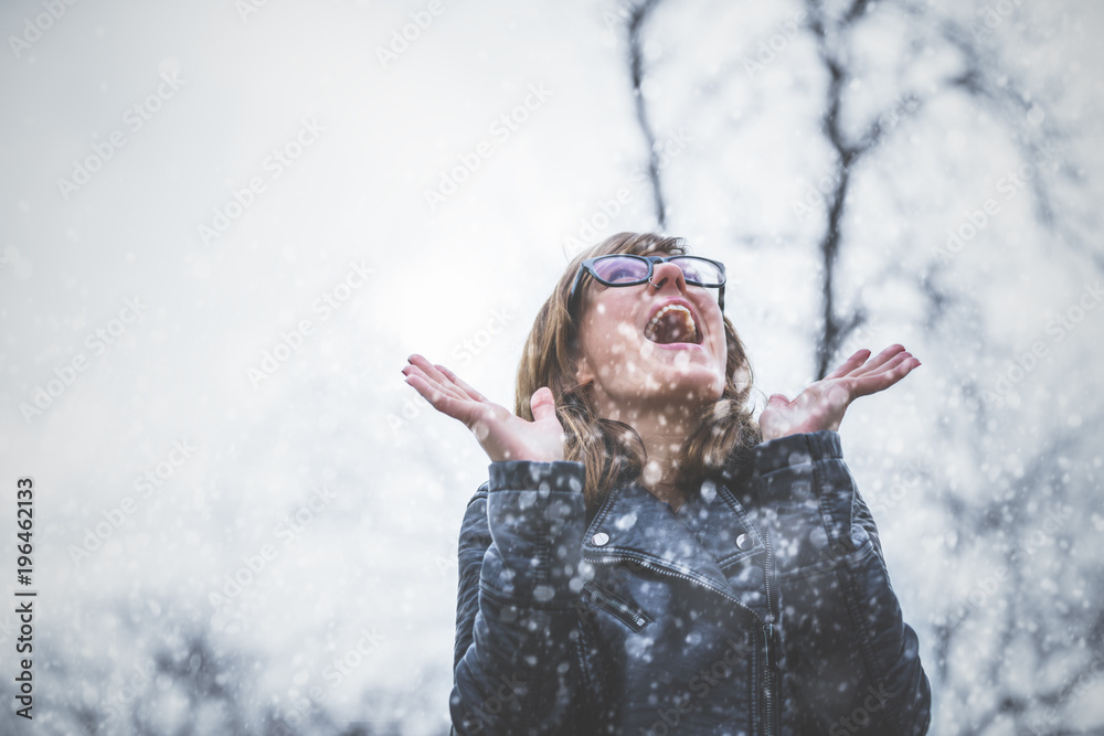 Fototapeta premium Snow falling and cute girl feeling happy outdoors.