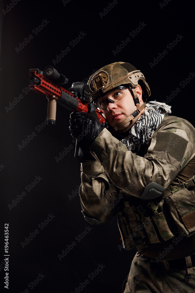 Portrait of aiming soldier with gun