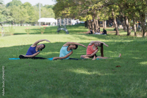 Family practicing yoga in the park outdoor. Concept of healthy lifestyle and relaxation..