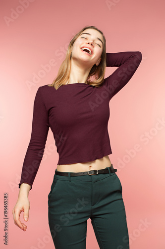 Woman smiling with perfect smile and white teeth on the pink studio background