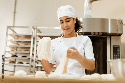 female baker preparing dough for pastry on baking manufacture