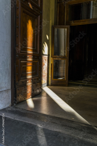 Architectural detail of St. Paul’s Cathedral in Rome. Wooden doors and shadows in Rome, Italy.