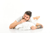 man yawning while waking up. unshaven man with tattoo