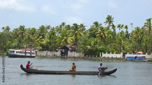Houseboats and activities along the river in the backwaters of Kerala, India.