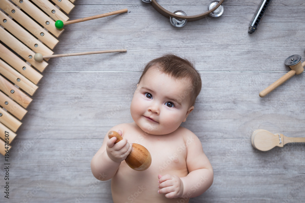 beautiful baby surrounded by several instruments - obrazy, fototapety, plakaty 