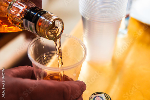 Pour the alcohol in a plastic disposable dishes.