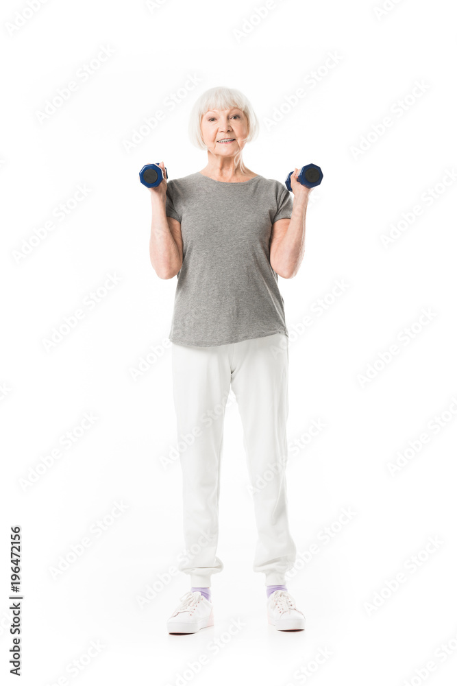 Senior sportswoman doing excercise with dumbbells isolated on white