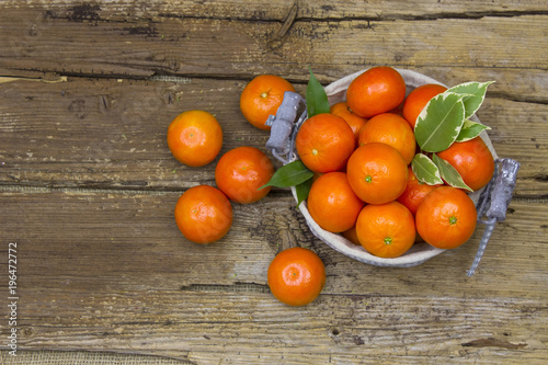 fresh tangerines in a basket on wooden background