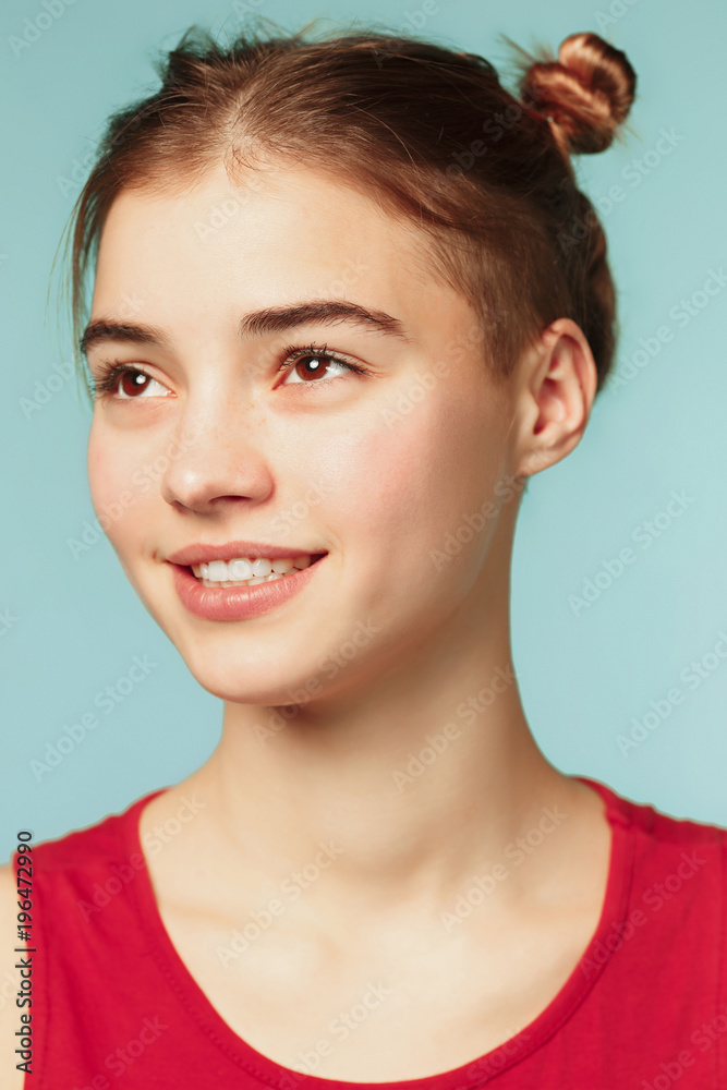Woman smiling with perfect smile on the blue studio background and looking at camera Woman smiling with perfect smile on the blue studio background and looking at camera