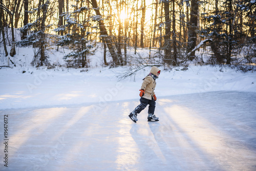 Boy ice-skating on a frozen lake photo