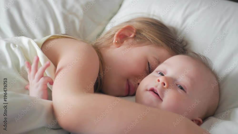 Lovely brother and sister lying in bed at home. Concept of Brother And Sister Together Forever Lovely brother and sister lying in bed at home. Concept of Brother And Sister Together Forever