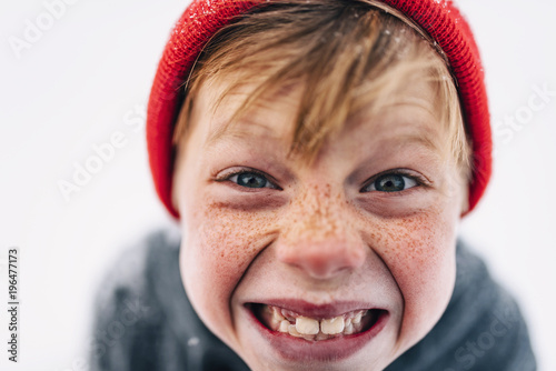 Portrait of a boy with freckles pulling funny faces photo