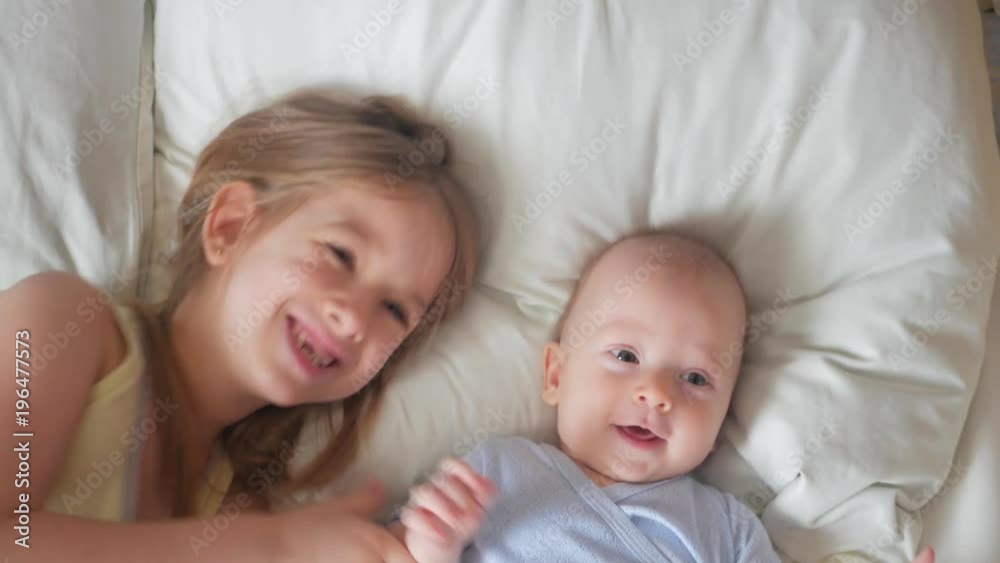 Lovely brother and sister lying in bed at home. Concept of Brother And Sister Together Forever Lovely brother and sister lying in bed at home. Concept of Brother And Sister Together Forever