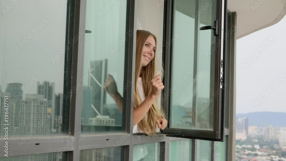 Young beautiful blonde woman looking out of the window,singing and dancing. Happiness,freedom concept. Young beautiful blonde woman looking out of the window,singing and dancing. Happiness,freedom concept.