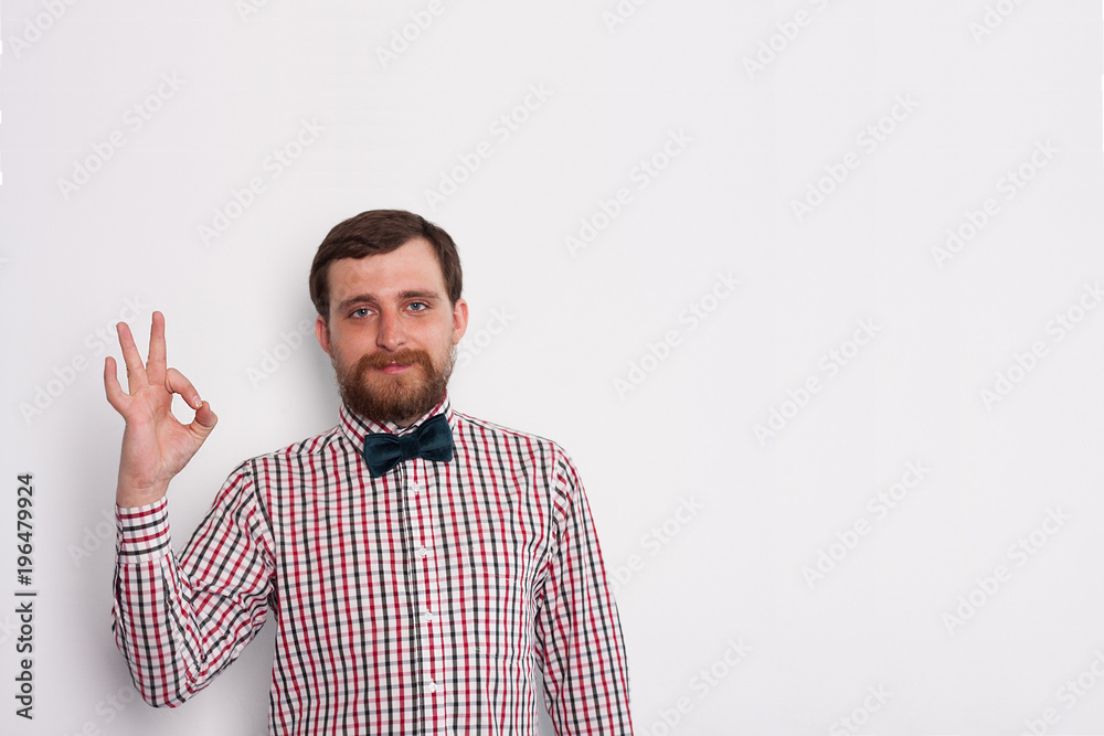 Fototapeta premium Young bearded caucasian man hipster show ok gesture in studio with white background