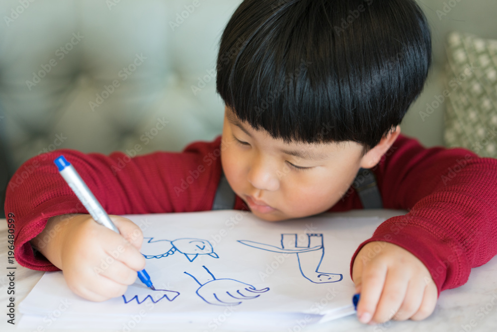 A Asian boy is drawing a picture. A Asian boy is drawing a picture.
