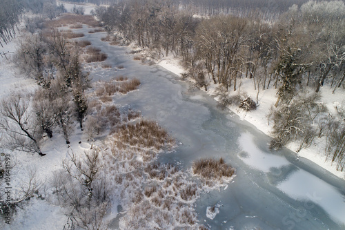 Winter landscape of frozen river in forest