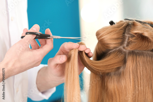 Professional hairdresser working with client in salon