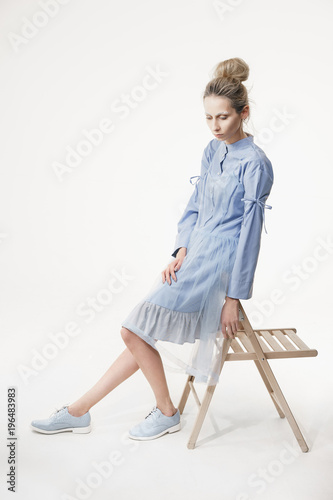 Fotografi Beautiful emotionless woman in blue garment