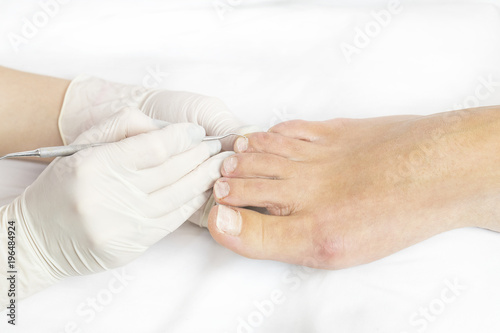 Female foot in the process of pedicure procedure in a beauty salon close-up. © lester120