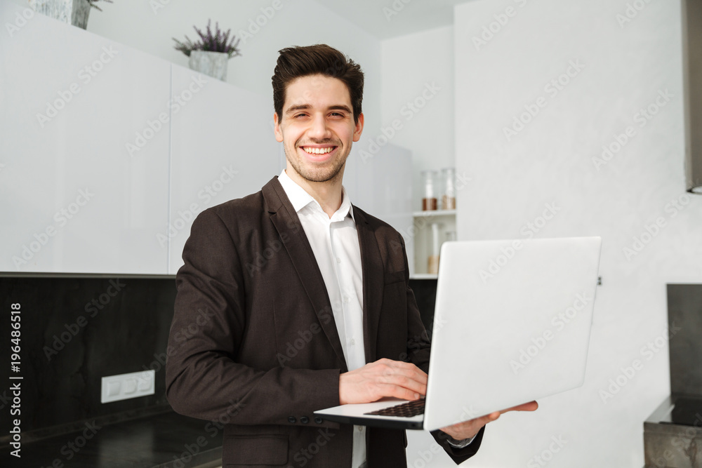 Happy young businessman using laptop computer. Happy young businessman using laptop computer.