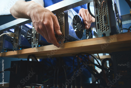 A young man sets up a farm for the extraction of cryptocurrency photo