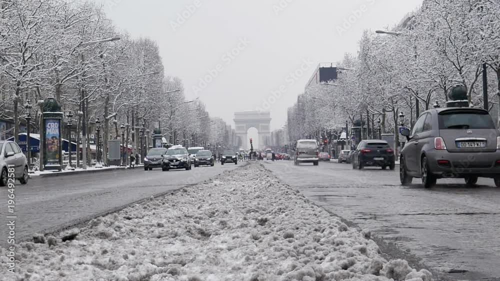 The arc de triumph by a rare snowy day in Paris, France