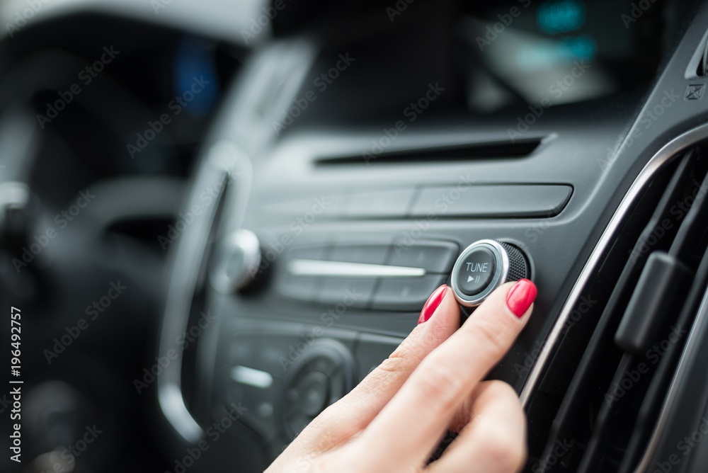 Woman changing frequency on car radio