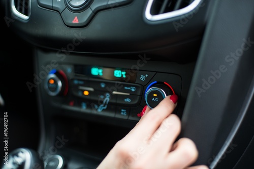 Woman turning on car air condition.