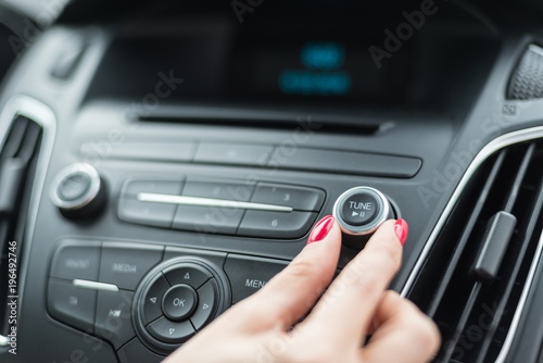 Woman changing frequency on car radio