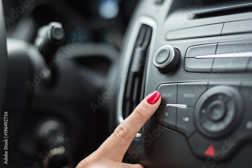 Woman turning on car radio