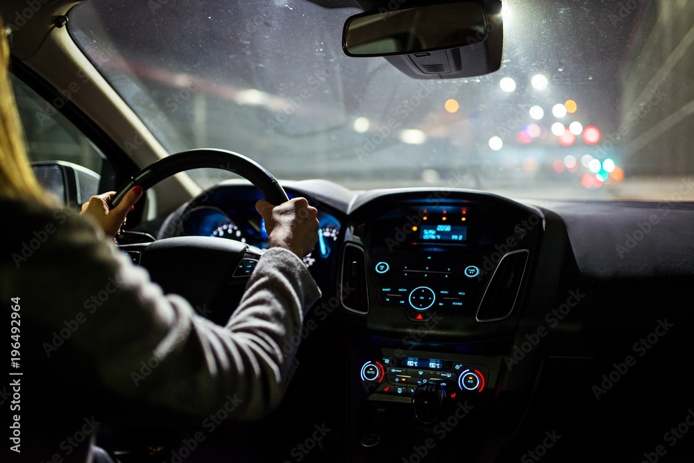 Young woman driving a car at night