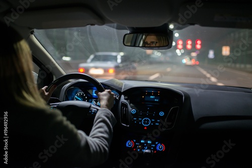 Young woman driving a car at night