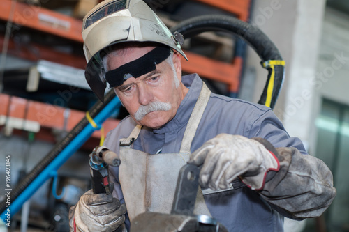 Senior worker using gas torch