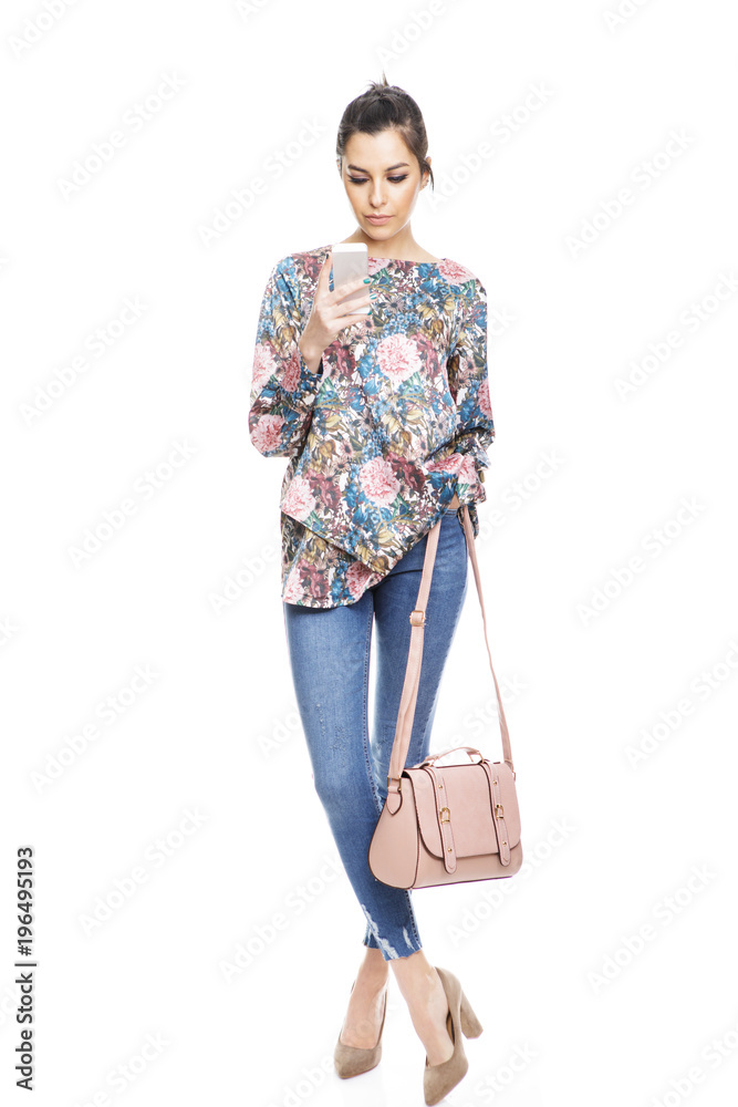 Full length portrait of stylish young woman using her cellphone Full length portrait of stylish young woman using her cellphone