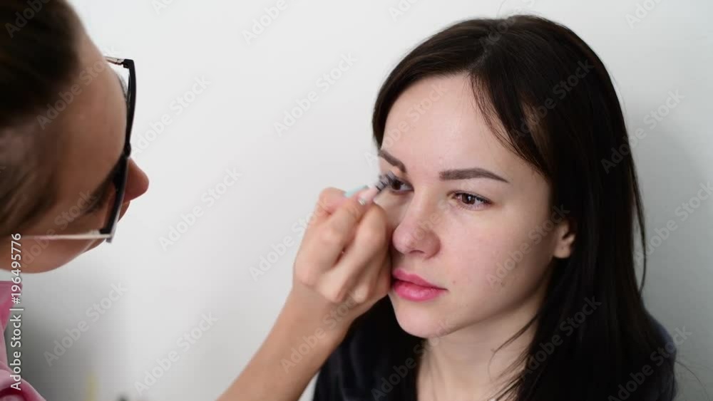 makeup artist paints eyebrows young dark-haired girls makeup artist paints eyebrows young dark-haired girls