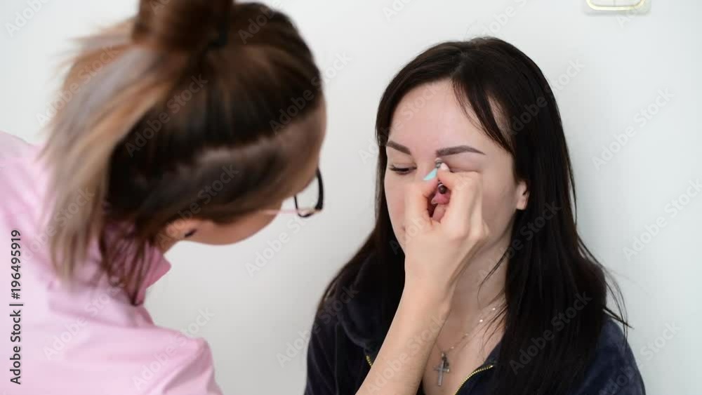 makeup artist paints eyebrows young dark-haired girls makeup artist paints eyebrows young dark-haired girls