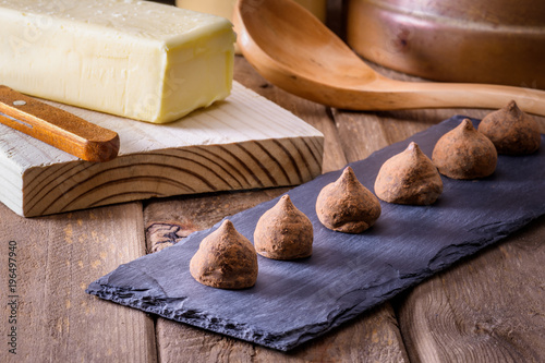 chocolate truffles on wooden table, with tea and butter block