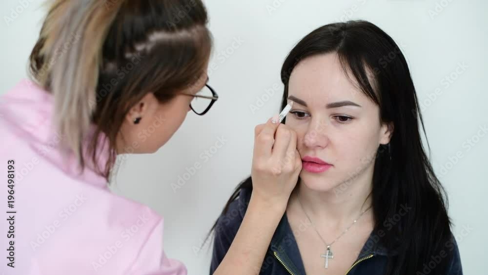 makeup artist paints eyebrows young dark-haired girls makeup artist paints eyebrows young dark-haired girls