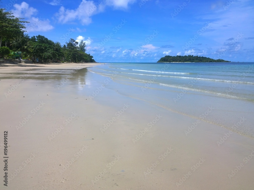 Blue sky and clouds over a beautiful tropical beach with green palm trees on Koh Chang island in Thailand