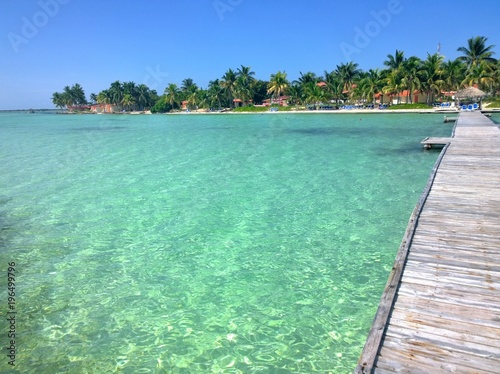 Blue sky over a beautiful tropical beach with green palm trees and pier. Cayo Guilermo , Cuba