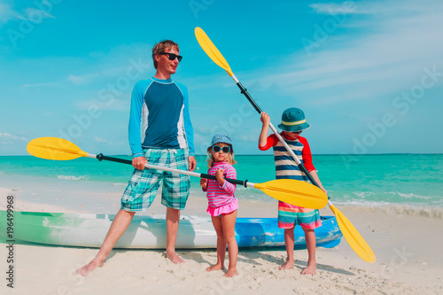 father with little son and daugther kayaking at beach