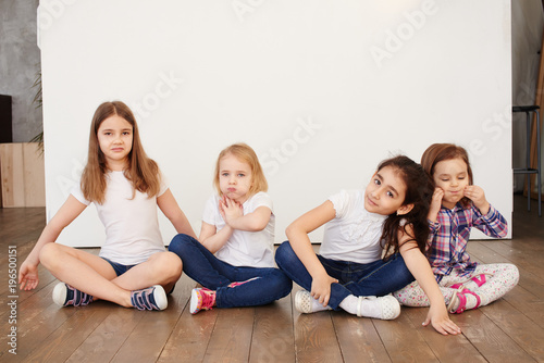 four little girls of a friend sitting on a white background happy relationships