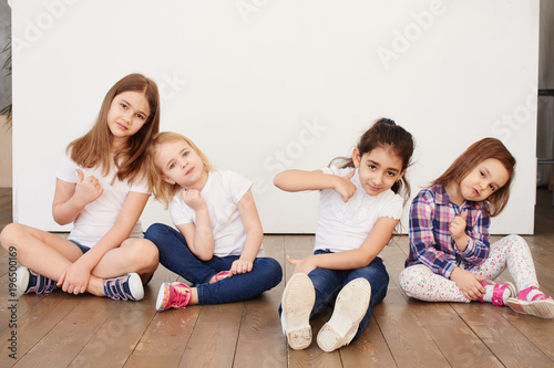 four little girls of a friend sitting on a white background happy relationships